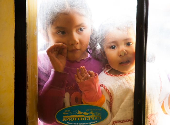 Peruvian children looking through glass